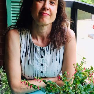 Sarah Newman sitting at table on balcony